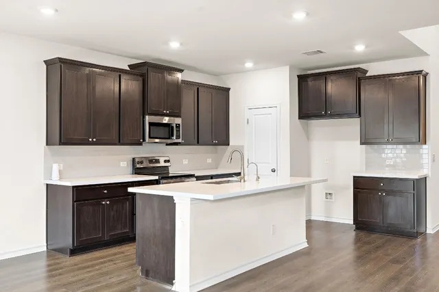 a kitchen with stainless steel appliances granite countertop a sink stove and microwave