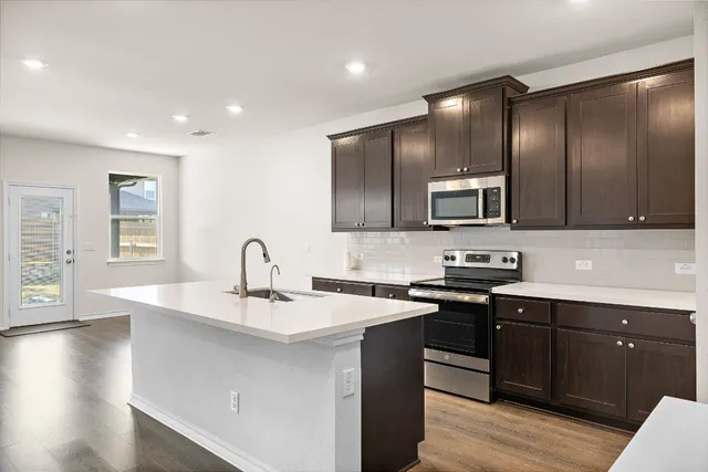 a kitchen with stainless steel appliances a sink stove and cabinets