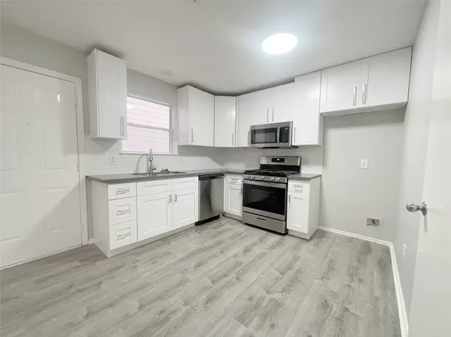 a kitchen with a stove a sink and a microwave