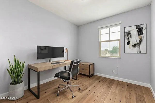 a view of a workspace with furniture and a window