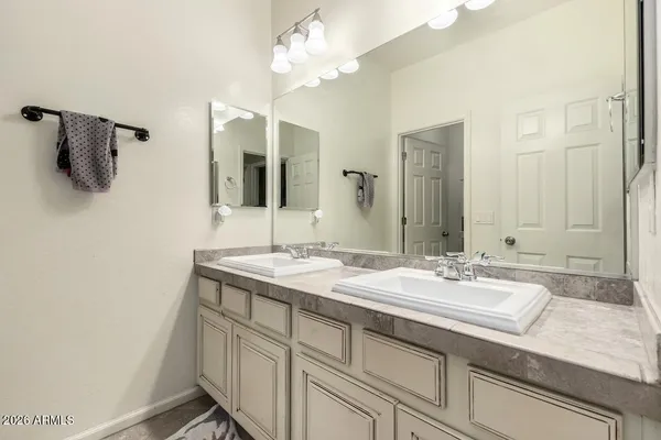 a bathroom with a sink double vanity granite and a mirror