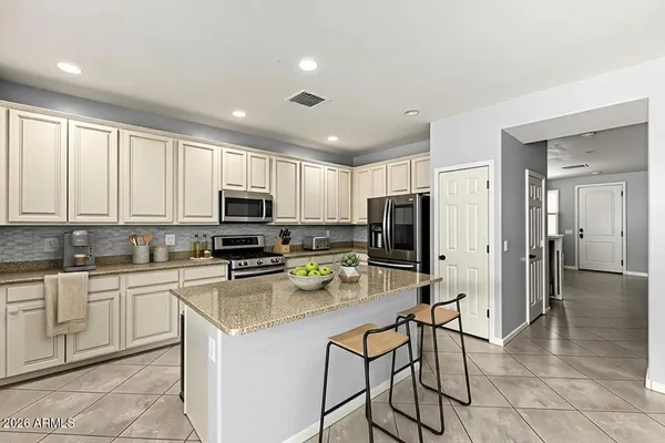 a kitchen with stainless steel appliances granite countertop a stove top oven a granite counter tops and white cabinets