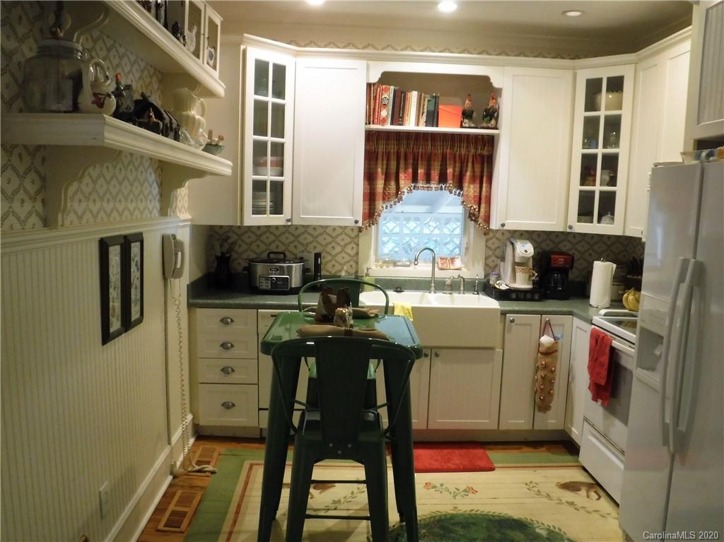 206 Callahan Street Rutherfordton, NC 28139 - Photo 14 of 48 a kitchen that has a lot of cabinets a refrigerator and a table in it