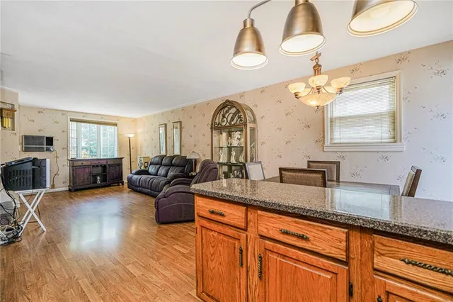 a large living room with granite countertop kitchen island stainless steel appliances a sink and a large window