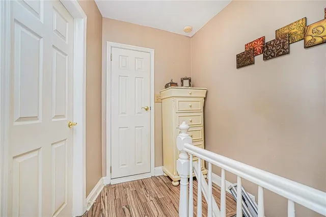 a view of a hallway with closet and wooden floor