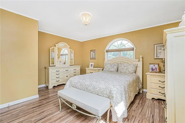 a bedroom with a bed and a painting on the wall