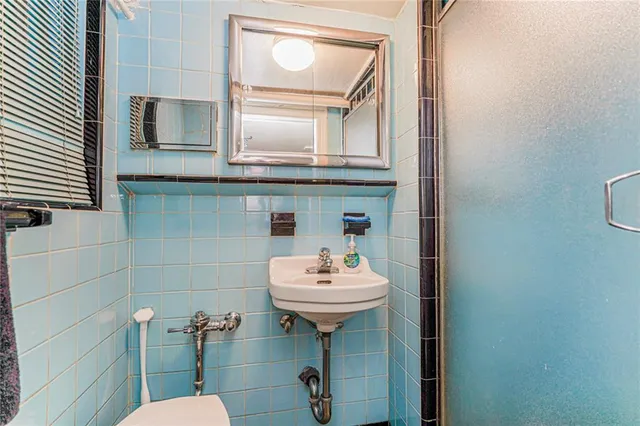 a bathroom with a sink toilet and mirror