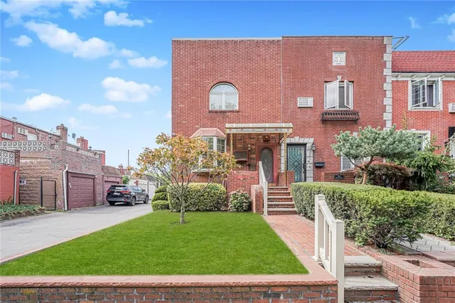 a front view of a house with a garden and plants