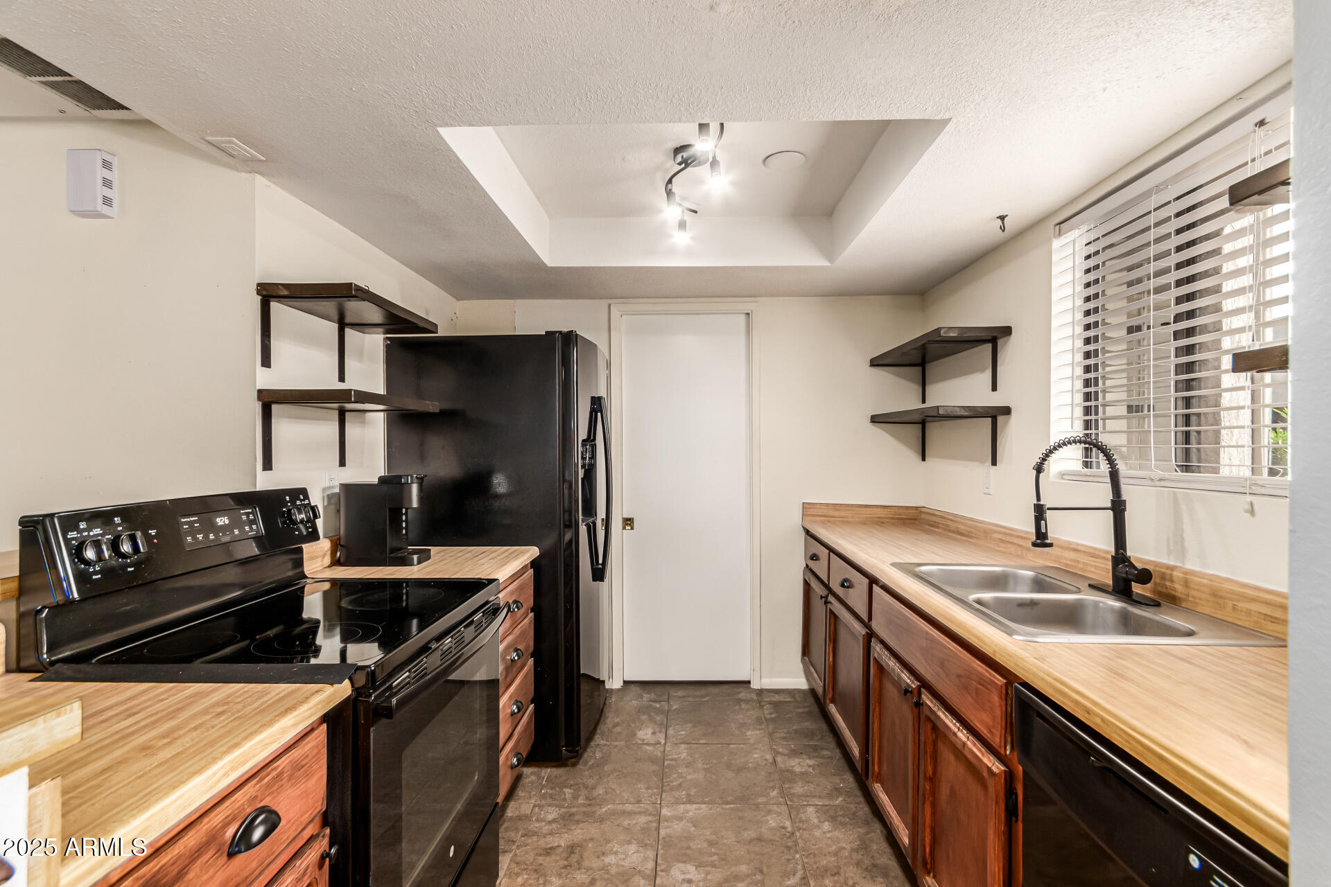 1352 East Highland Avenue, Unit 117 Phoenix, AZ 85014 - Photo 13 of 25 a kitchen with stainless steel appliances granite countertop a sink stove and refrigerator