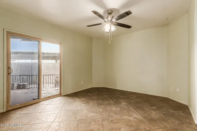an empty room with closet and ceiling fan