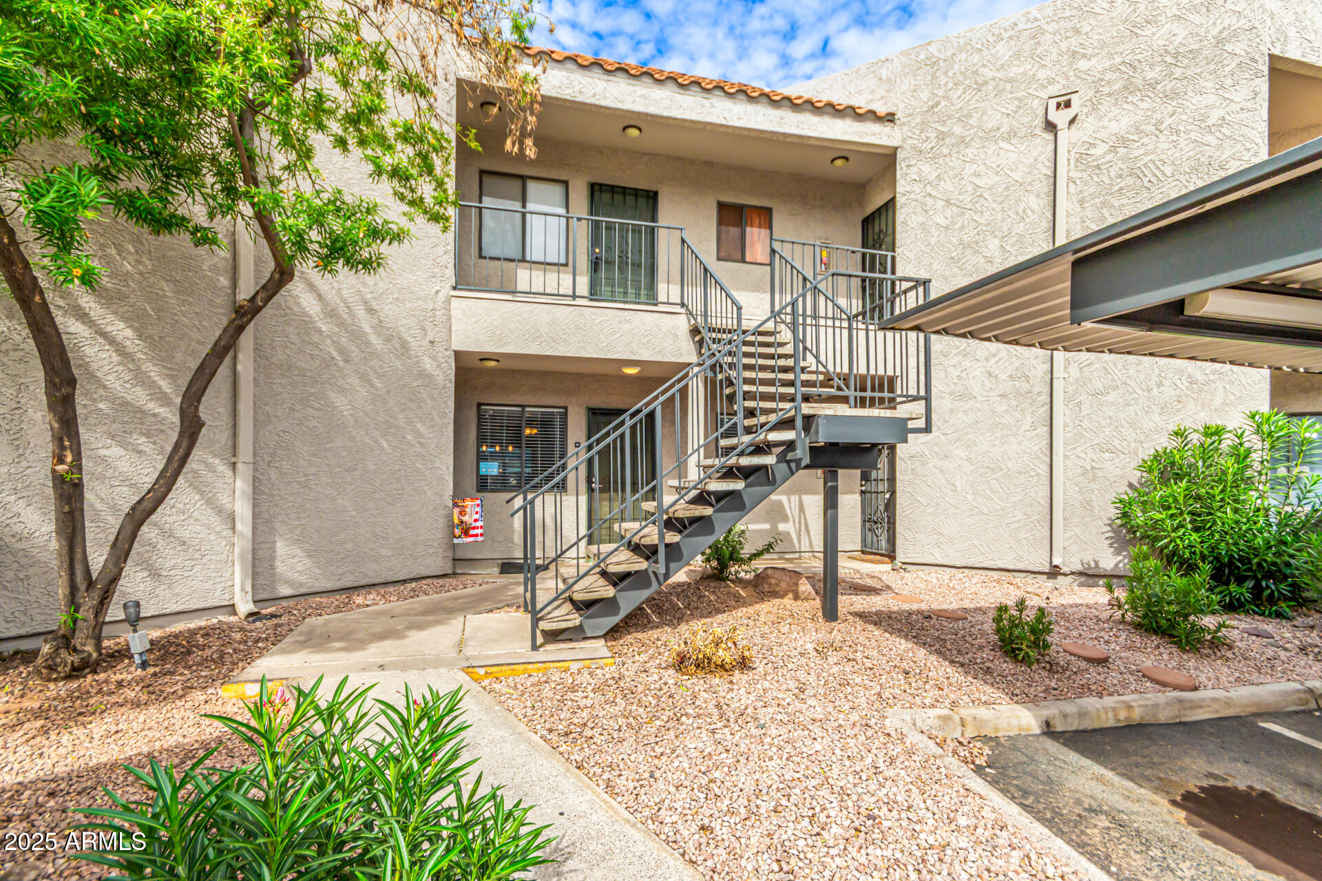 1352 East Highland Avenue, Unit 117 Phoenix, AZ 85014 - Photo 5 of 25 a view of a house with large windows and flower plants