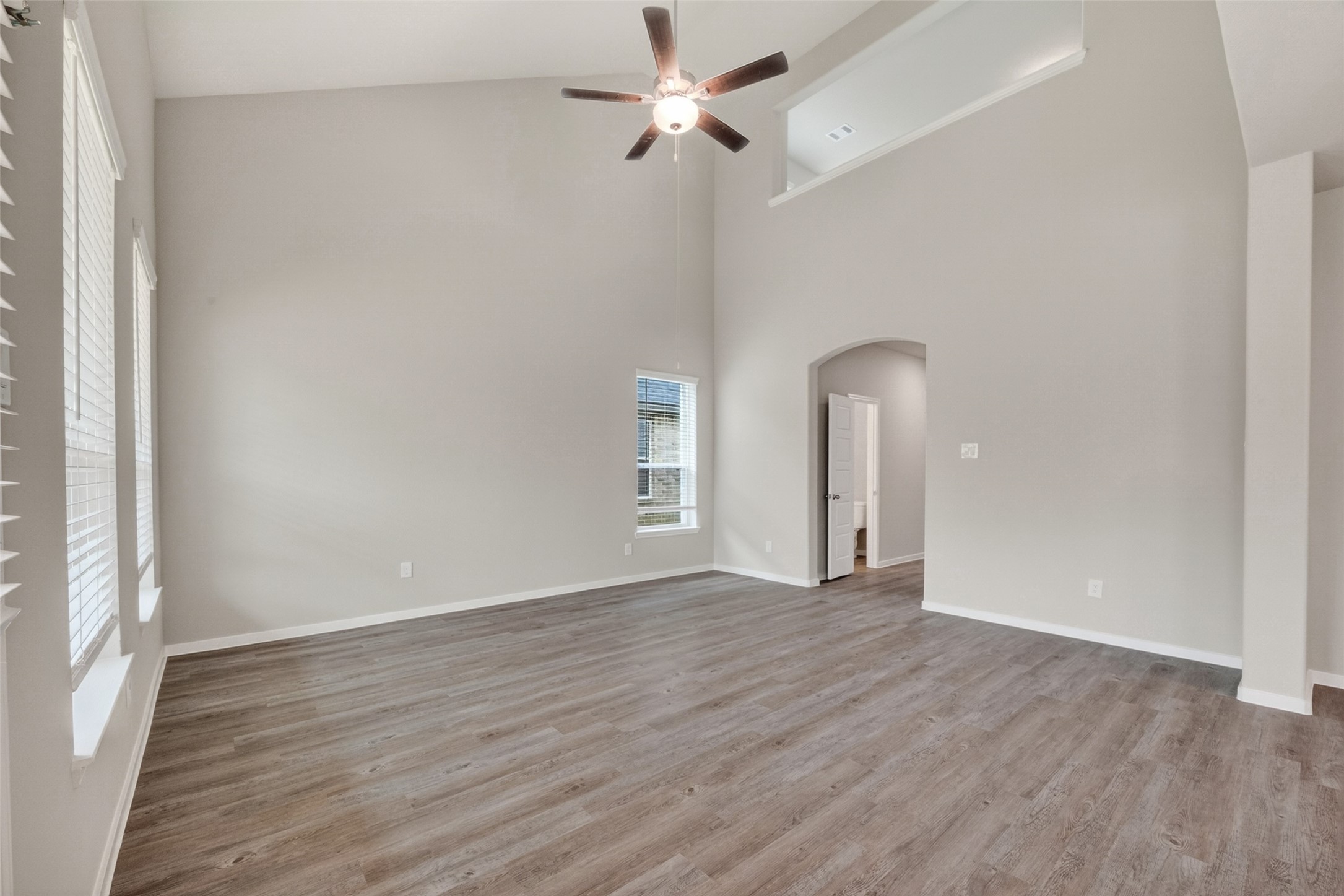 2107 Spring Hollow Drive Baytown, TX 77521 - Photo 6 of 42 an empty room with wooden floor ceiling fan and windows
