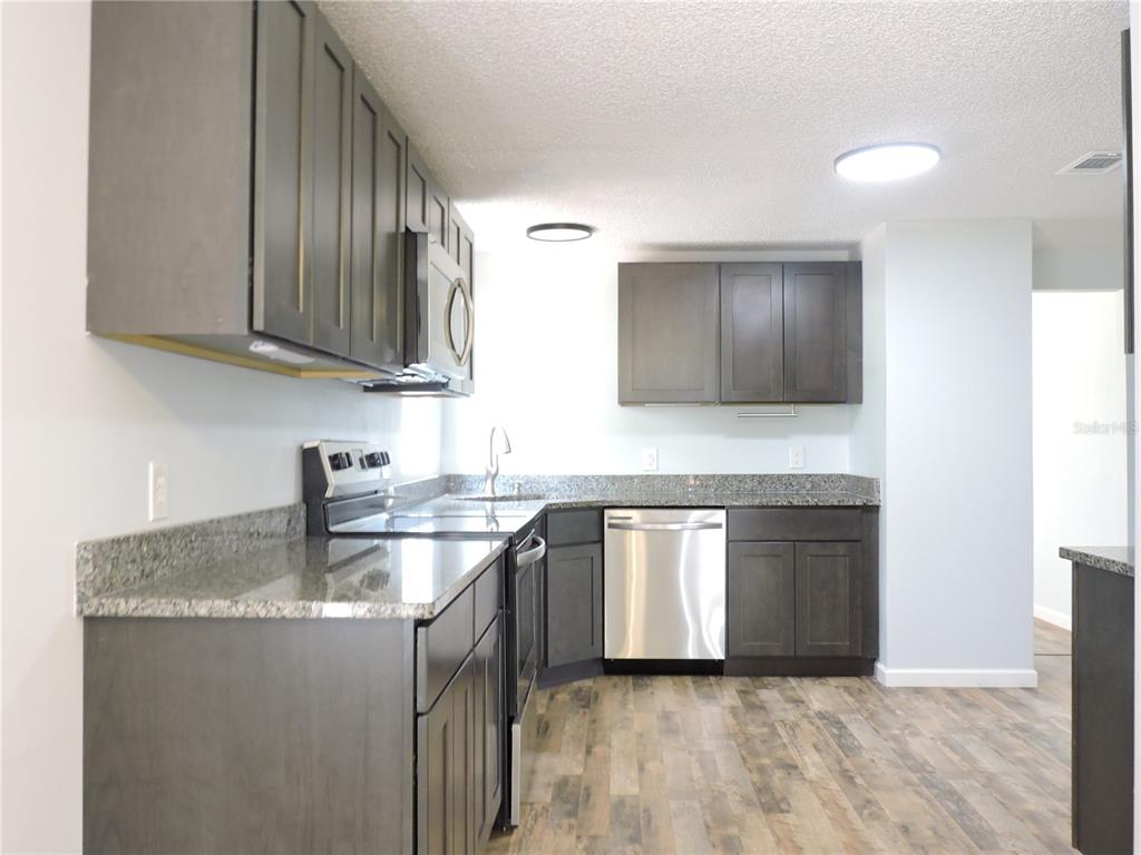 294 Tiger Lake Road Lake Wales, FL 33898 - Photo 15 of 56 a kitchen with stainless steel appliances granite countertop a sink stove and cabinets