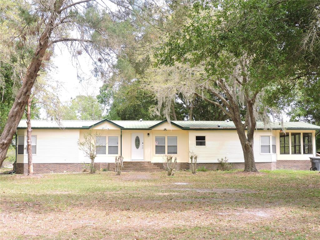 294 Tiger Lake Road Lake Wales, FL 33898 - Photo 2 of 56 a view of a white house with a big yard and large trees