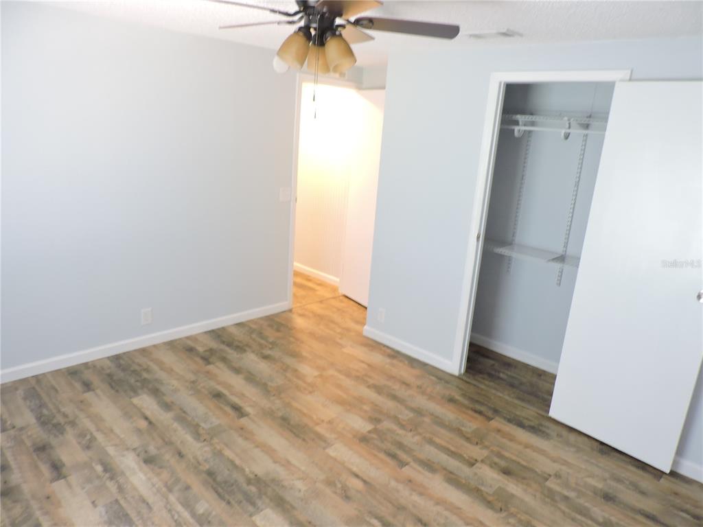 294 Tiger Lake Road Lake Wales, FL 33898 - Photo 31 of 56 an empty room with wooden floor and a bathroom