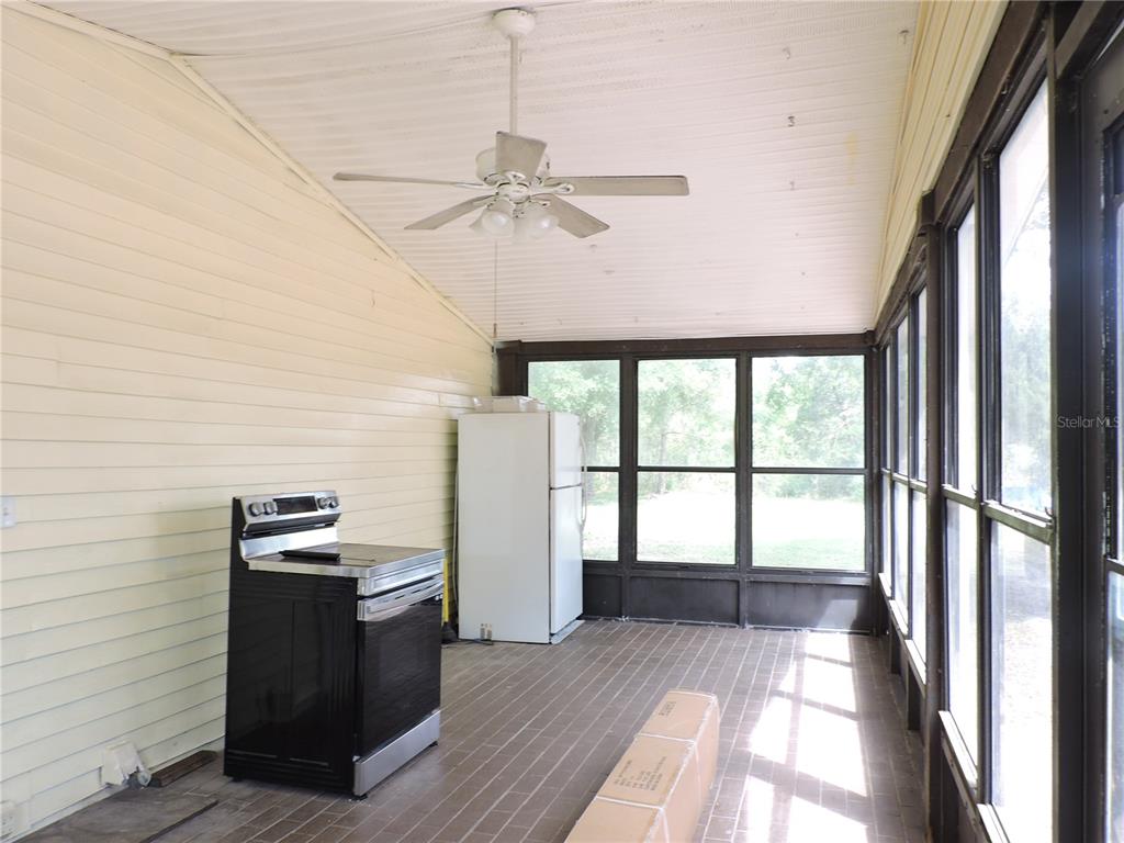294 Tiger Lake Road Lake Wales, FL 33898 - Photo 40 of 56 a view of a kitchen with a stove wooden floor and a ceiling fan