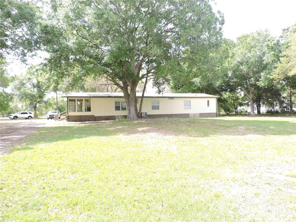 294 Tiger Lake Road Lake Wales, FL 33898 - Photo 42 of 56 a view of a swimming pool with a lawn chairs under an umbrella