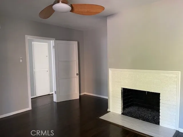 an empty room with wooden floor and fireplace