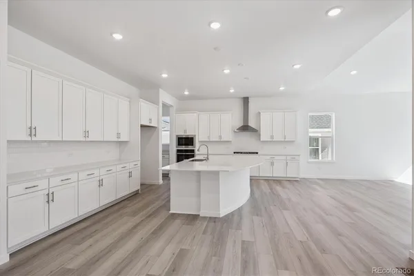 a large kitchen with kitchen island a sink a center island stainless steel appliances and a cabinets