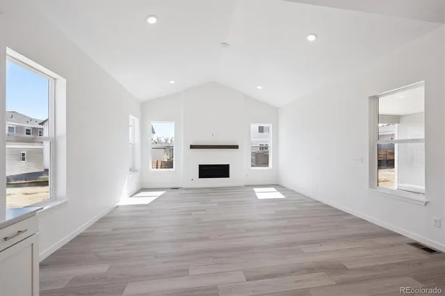 a view of empty room with wooden floor and window