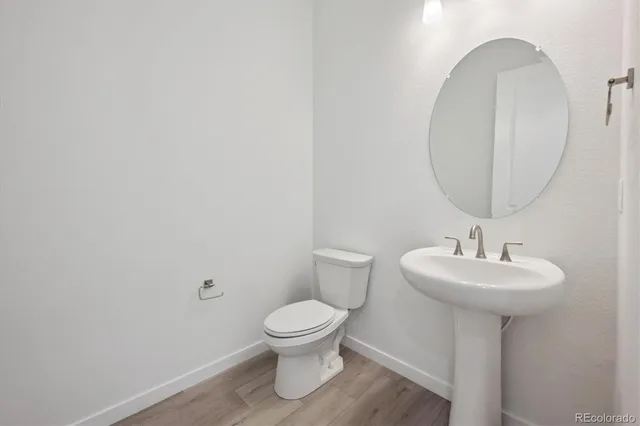 a bathroom with a sink toilet and a mirror