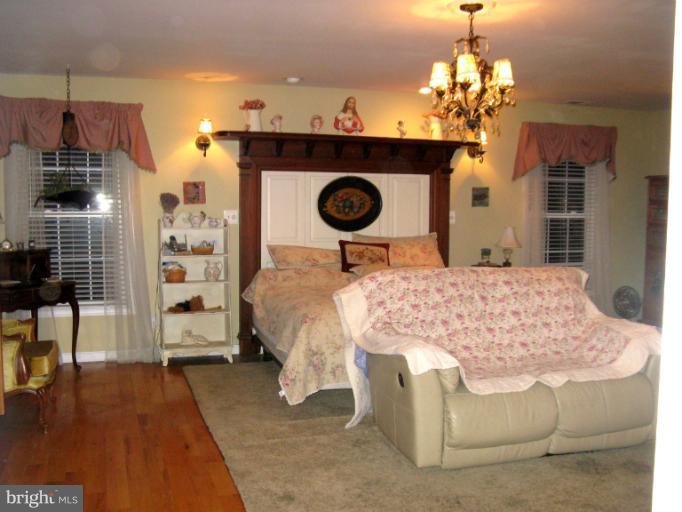 310 Greenwood Road Linthicum, MD 21090 - Photo 13 of 26 a bedroom with a bed and a chandelier