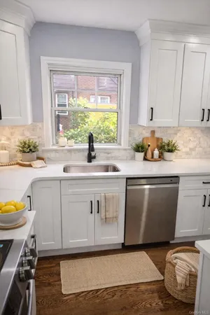 a kitchen with a sink a stove cabinets and wooden floor