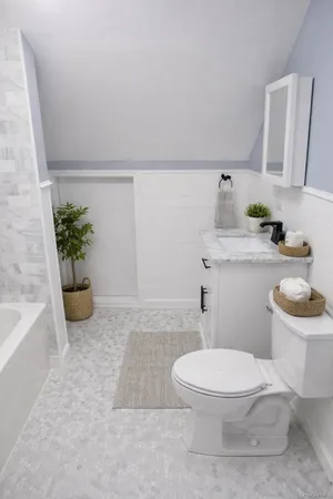 a white toilet sitting next to a bathroom sink and tub