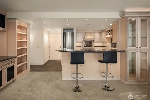 a kitchen with stainless steel appliances kitchen island granite countertop a refrigerator and cabinets