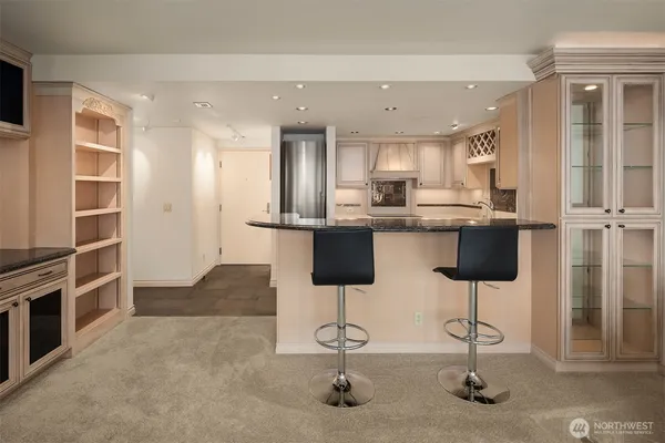 a kitchen with stainless steel appliances kitchen island granite countertop a refrigerator and cabinets