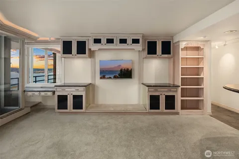 a living room with stainless steel appliances furniture and a kitchen view