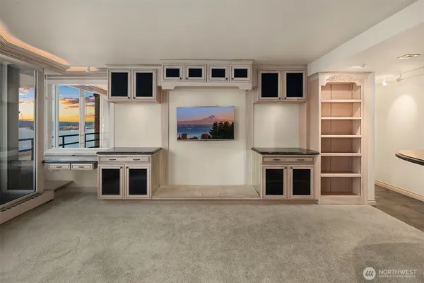 a living room with stainless steel appliances furniture and a kitchen view