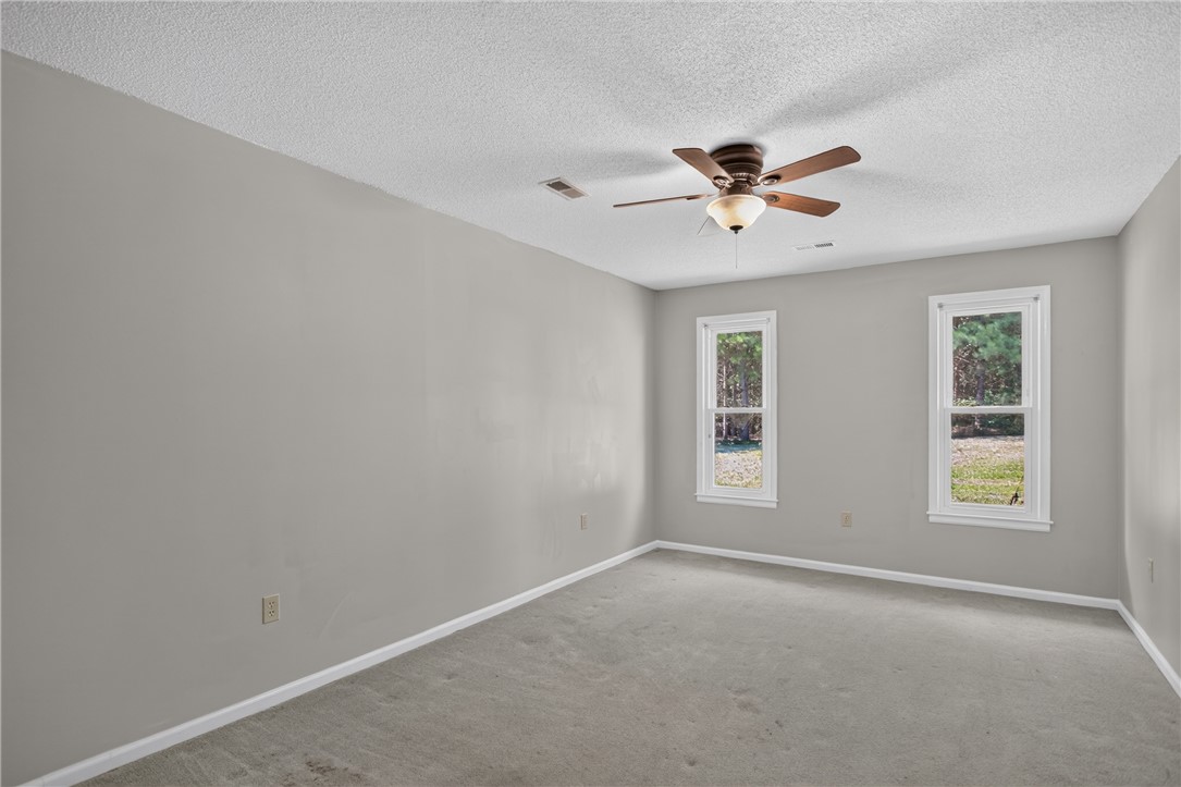 1412 Simpson Road Pendleton, SC 29670 - Photo 33 of 48 A quiet bedroom offers serene outdoor views and optimal air circulation from the ceiling fan.