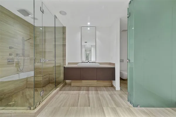 a bathroom with a tub shower vanity and sink