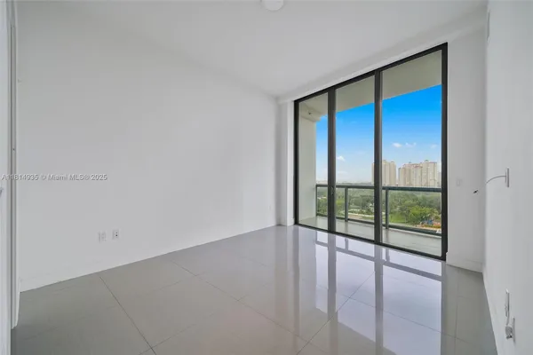 an empty room with sliding glass door and garden view