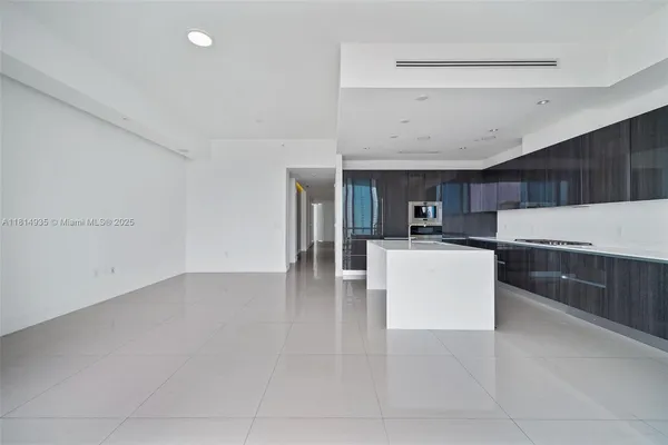 a view of kitchen with cabinets microwave and refrigerator