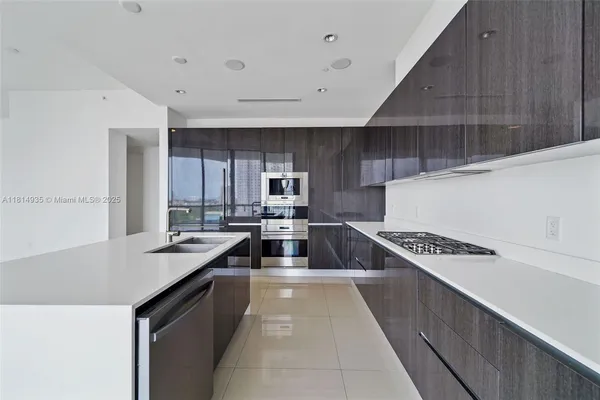 a kitchen with granite countertop a sink a stove and cabinets