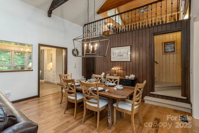 a dining room with furniture a chandelier and wooden floor