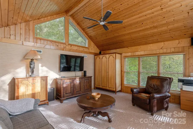 a living room with furniture a flat screen tv and a large window
