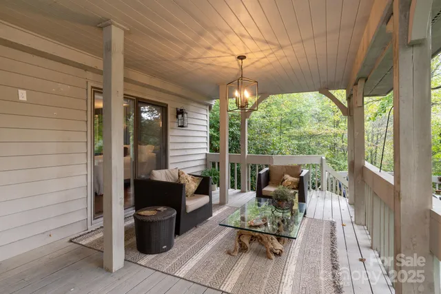 a view of a patio with couches chairs potted plants and wooden floor