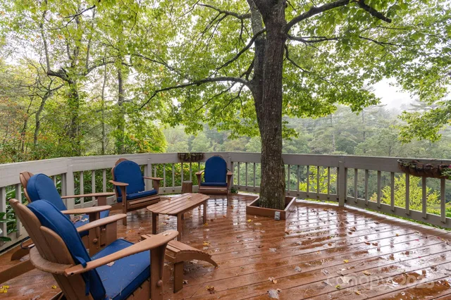 a view of deck with furniture and trees around
