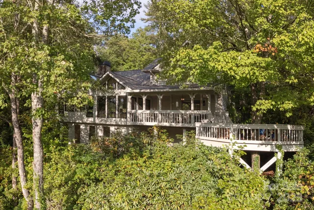 a front view of a house with swimming pool and porch with furniture