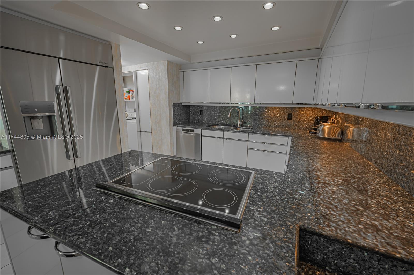 9801 Collins Avenue, Unit 14D Bal Harbour, FL 33154 - Photo 6 of 25 a kitchen with stainless steel appliances granite countertop a sink stove and refrigerator