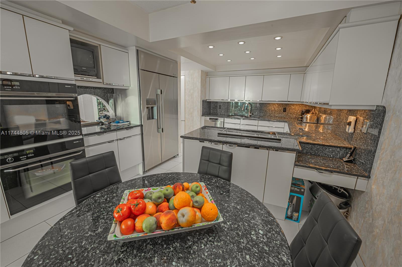 9801 Collins Avenue, Unit 14D Bal Harbour, FL 33154 - Photo 8 of 25 a kitchen with stainless steel appliances granite countertop a stove a sink and a refrigerator