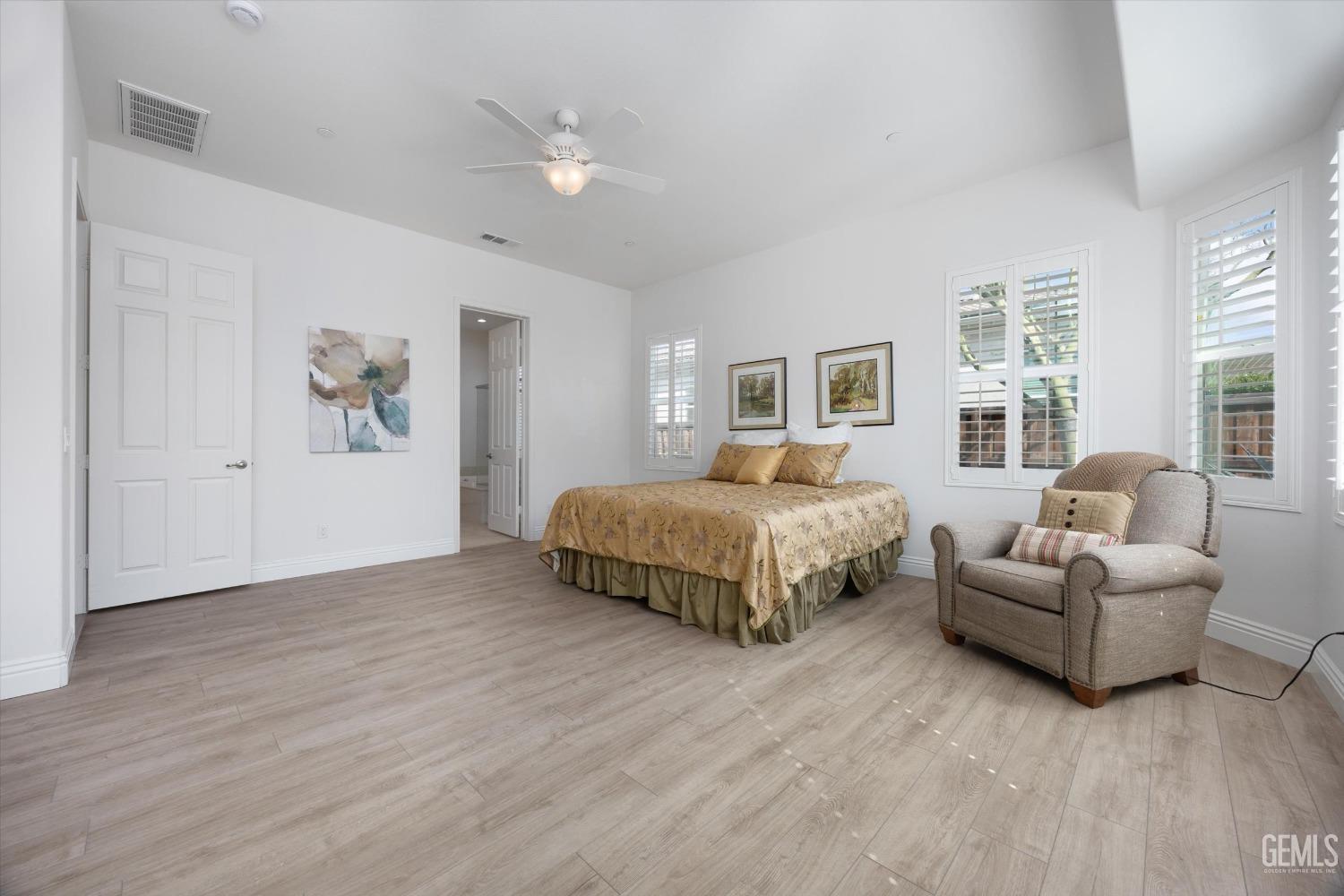 Undisclosed Address Bakersfield, CA 93306 - Photo 19 of 70 a spacious bedroom with a bed a couch and a window
