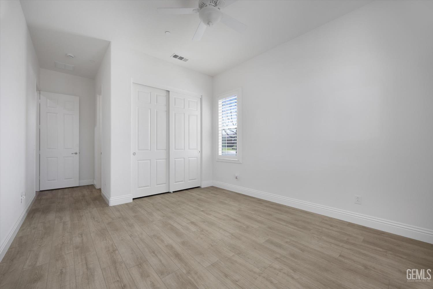 Undisclosed Address Bakersfield, CA 93306 - Photo 25 of 70 an empty room with wooden floor and windows