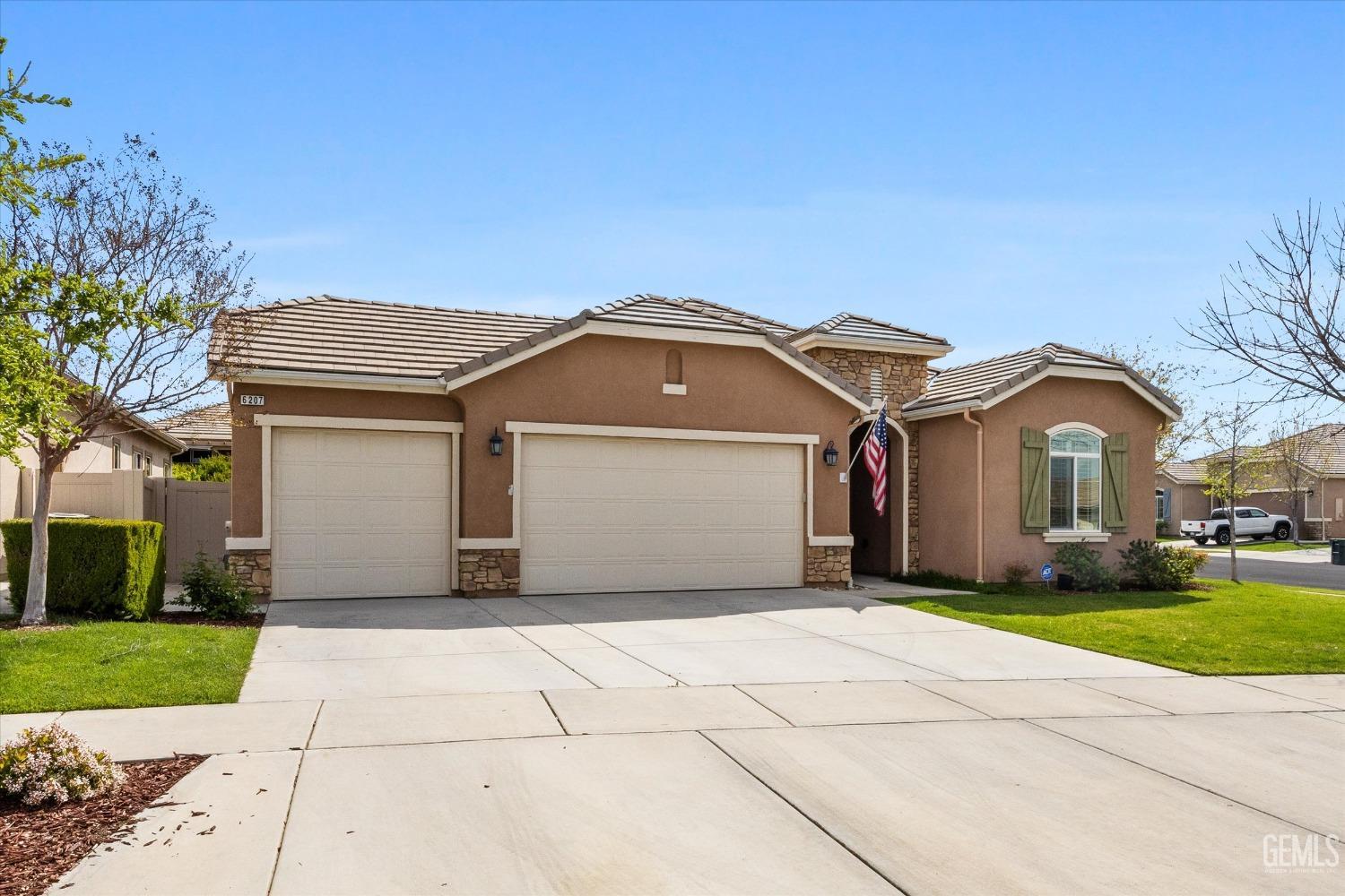 Undisclosed Address Bakersfield, CA 93306 - Photo 39 of 70 a front view of a house with a yard and garage
