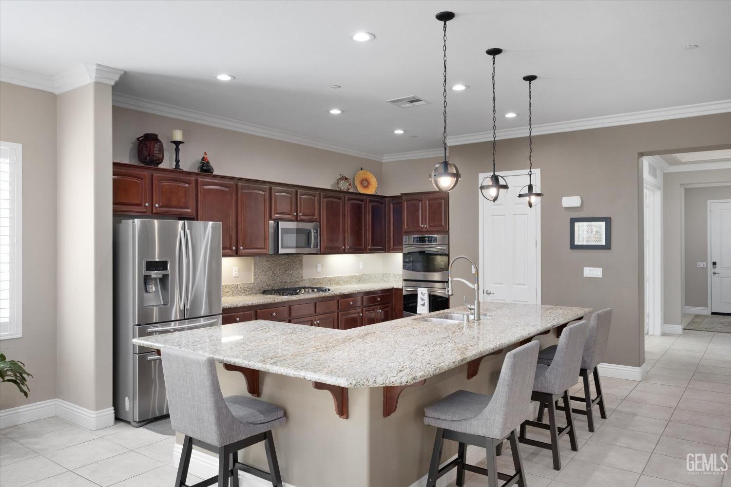 Undisclosed Address Bakersfield, CA 93306 - Photo 5 of 70 a kitchen with granite countertop a table chairs stainless steel appliances and cabinets