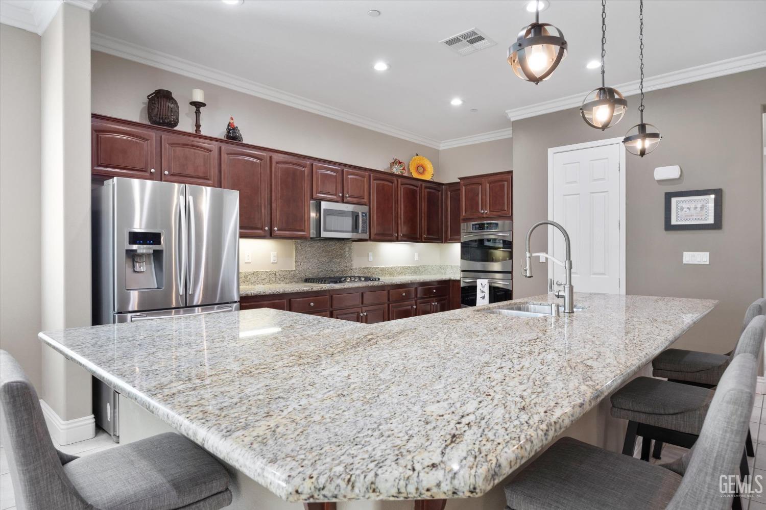 Undisclosed Address Bakersfield, CA 93306 - Photo 6 of 70 a kitchen with stainless steel appliances granite countertop a sink a stove and a wooden cabinets