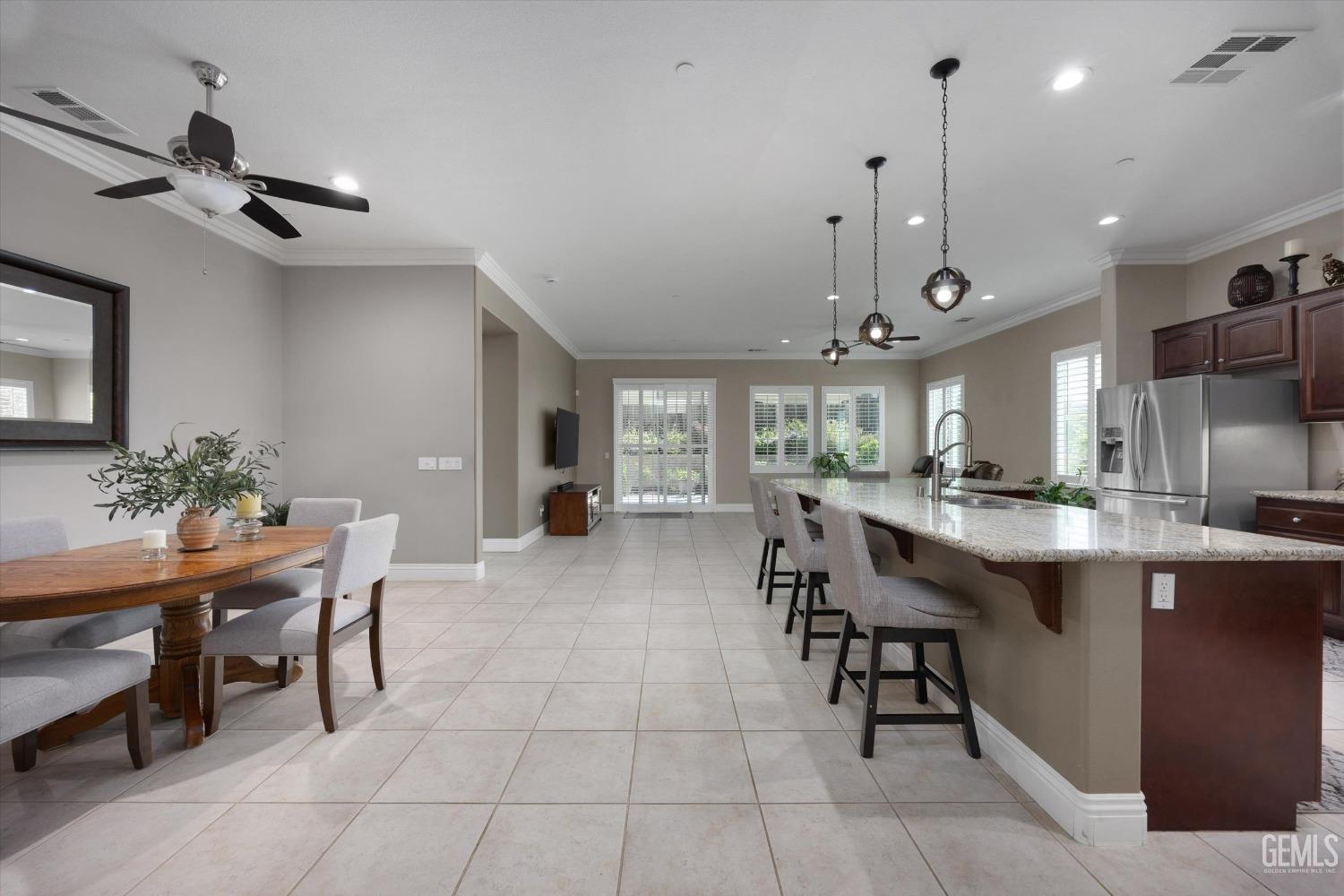 Undisclosed Address Bakersfield, CA 93306 - Photo 9 of 70 a dining hall with stainless steel appliances kitchen island granite countertop a table and chairs in it